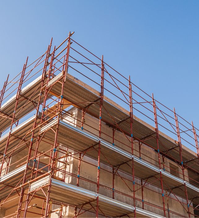 Baugerüst an einem Gebäude vor blauem Himmel